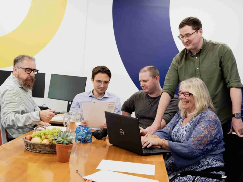 Photo Of GWCU Finance Team Working Together At A Table With Laptops And Papers Photo Of GWCU Finance Team Working Together At A Table With Laptops And Papers