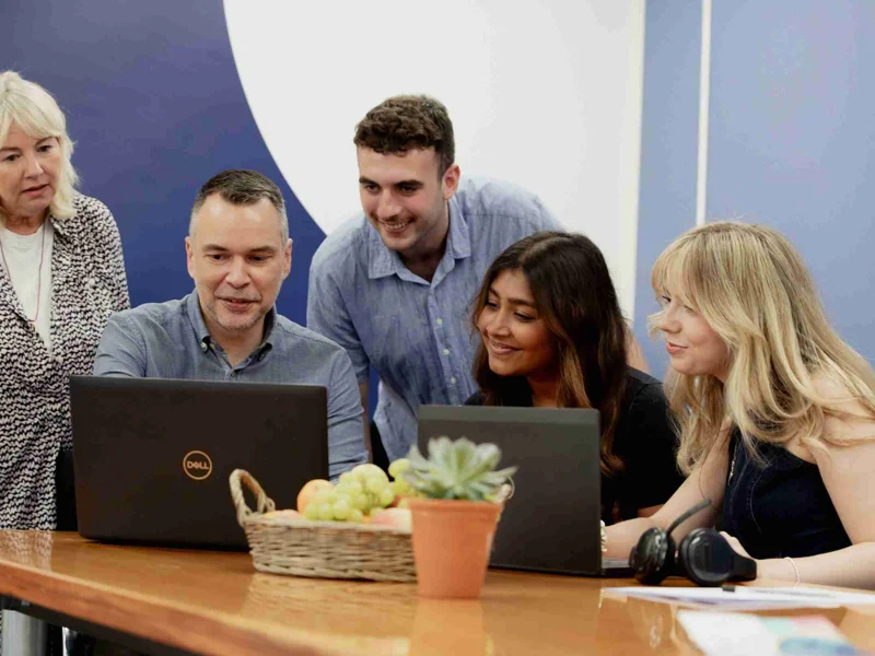 Photo Of GWCU Growth Team Working On A Laptop Together Photo Of GWCU Growth Team Working On A Laptop Together